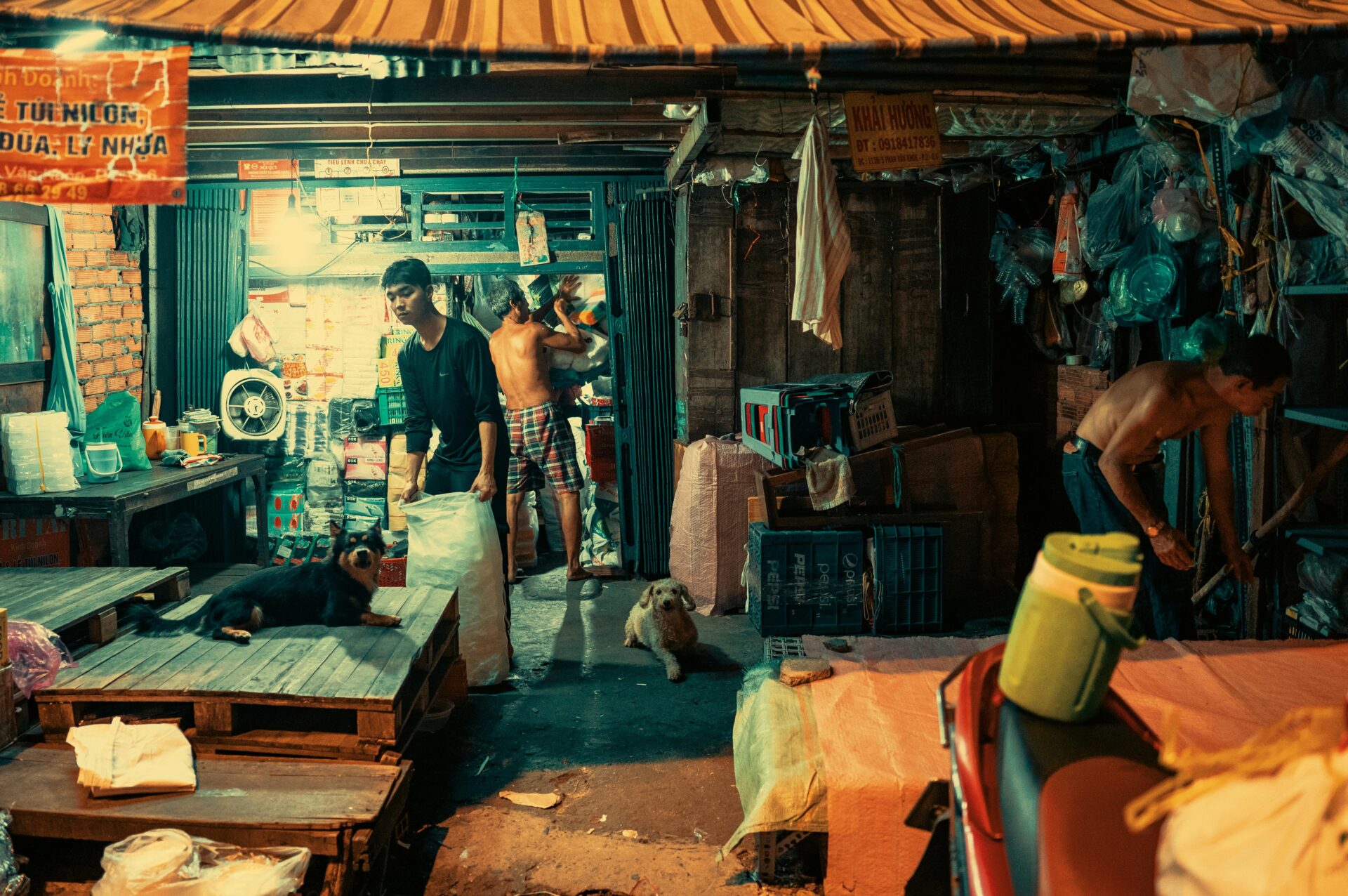 1‑Euro‑Angebote: Kalkulation, Upsell‑Strategien und Limits 2 Lebhaftes Nachtmarkt-Geschehen mit arbeitenden Menschen und Hunden, die an einem Stand ruhen.